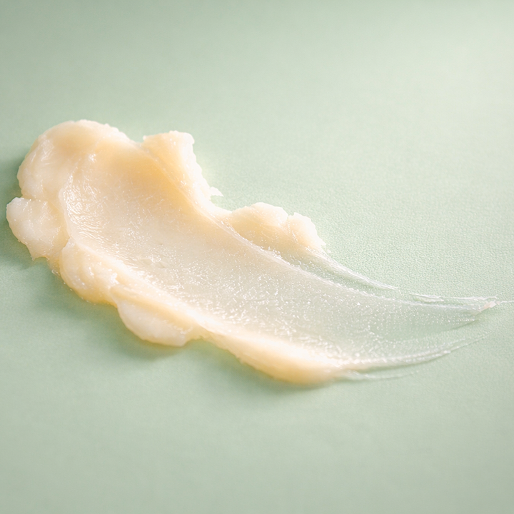 White cream smear on a light green background